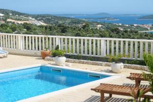 een zwembad op een balkon met een wit hek bij Family-friendly apartments with swimming pool Dvornica, Rogoznica - 11470 in Rogoznica