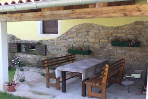 a table and two benches under a stone wall at Family friendly apartments with a swimming pool Cepic, Central Istria - Sredisnja Istra - 15878 in Kršan