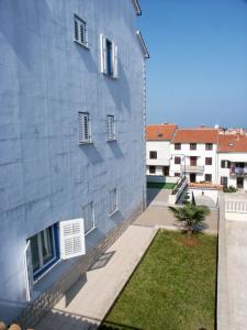 a blue building with a grass yard next to it at Studio Vrsar 3007a in Vrsar