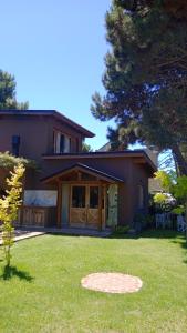 a house with a green lawn in front of it at Alma in Pinamar +5 photos