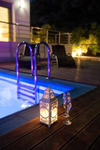キサモスにあるVilla Levantes Ferienhaus In Mithimna Mit Poolのプールサイドのテーブルの上にキャンドルとワイングラス