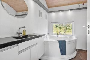 ein weißes Badezimmer mit Waschbecken und Fenster in der Unterkunft JB403 Fjerritslev - Poppelvej 20 in Fjerritslev + 20 Fotos