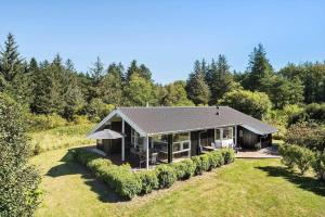 ein Haus mitten auf einem Feld mit Bäumen in der Unterkunft JB403 Fjerritslev - Poppelvej 20 in Fjerritslev