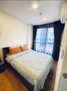 a bedroom with a large bed and a large window at The Central Escape Phuket in Ban Rangeng