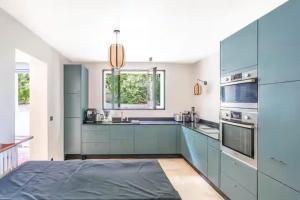 een grote keuken met blauwe kasten en een wastafel bij House, garden, Eiffel Tower, Palace of Versailles in Sèvres