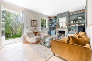 een woonkamer met een bank en een open haard bij House, garden, Eiffel Tower, Palace of Versailles in Sèvres