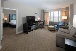 una camera d'albergo con divano, letto e TV di The Marc Hotel a Milwaukee