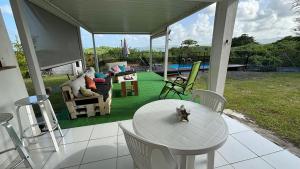 ル・ロベールにあるVilla KLYTANLYのポーチ(テーブル、椅子付)、プール