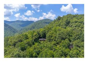 Come relax in the mountains of Otto NC في Otto: اطلالة جوية على جبل وفيه بيت وسط