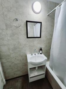 ein Badezimmer mit einem weißen Waschbecken und einer Dusche in der Unterkunft Monoambiente y sala de estar con garage in Mar del Plata