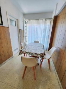 ein Esszimmer mit einem Tisch und weißen Stühlen in der Unterkunft Monoambiente y sala de estar con garage in Mar del Plata