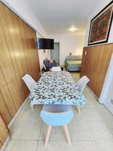 ein Esszimmer mit einem Tisch und einem Bett in der Unterkunft Monoambiente y sala de estar con garage in Mar del Plata + 8 Fotos