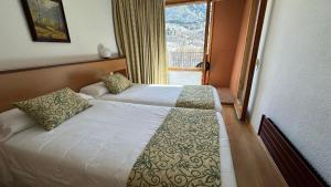 ein Hotelzimmer mit zwei Betten und einem Fenster in der Unterkunft Evenia Monte Alba in Aramón Cerler