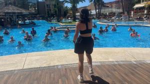 a woman in a bikini standing in a swimming pool at Evenia Olympic Garden in Lloret de Mar