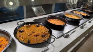 a group of bowls of food on a stove at Evenia Olympic Garden in Lloret de Mar