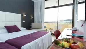 a hotel room with a bed and a bowl of fruit at Evenia Olympic Garden in Lloret de Mar +59 photos