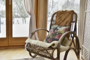 a wicker rocking chair sitting in front of a window at La yourte de l'Abreuvoir in Neufchâteau