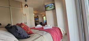 ein Schlafzimmer mit einem Bett und einem Fernseher an der Wand in der Unterkunft Bahia Marinas in Ushuaia
