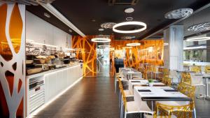 バルセロナにあるイヴェニア ロセージョのテーブルと椅子とキッチンのあるレストラン