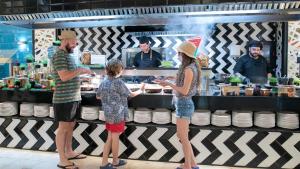 Un grupo de personas de pie frente a un mostrador de comida en Evenia Olympic Palace, en Lloret de Mar 61 fotos más