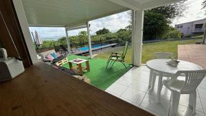 a screened in porch with a table and chairs at Villa KLYTANLY in Le Robert
