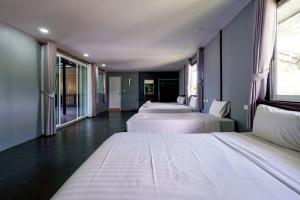 een kamer met drie bedden en ramen bij 7Sea Beach Pool Villa in Ao Nam Mao +104 foto's