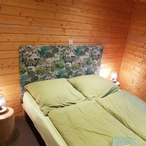 a bed in a room with a wooden wall at Ferienhaus In Atzenhain Mit Großer Terrasse in Mücke +9 photos