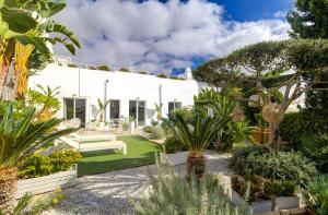 einen Garten mit einem weißen Haus mit Pflanzen in der Unterkunft Vila Rafa in Albufeira