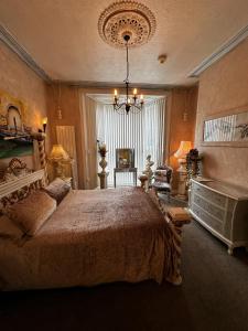 a bedroom with a large bed and a chandelier at Spend this night in Venice whilst visiting Swansea in Swansea