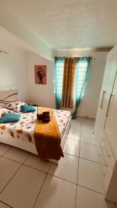 ル・ロベールにあるVilla KLYTANLYのベッドルーム1室(ベッド2台、青いカーテン付)