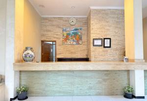 a lobby with a counter with a clock on the wall at De View Hotel By PRO in Punten +53 photos
