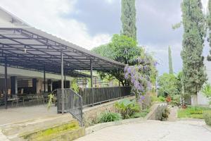 a building with a metal roof with trees and flowers at De View Hotel By PRO in Punten