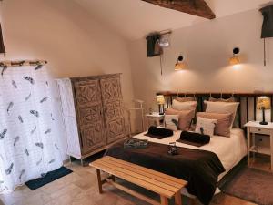 a bedroom with a large bed and a wooden bench at "La Petite Félixière" à 25 min du Puy du Foù, 10 min de Cholet, et 35 min de Nantes in Saint-André-de-la-Marche