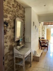 a bathroom with a sink and a mirror on a stone wall at "La Petite Félixière" à 25 min du Puy du Foù, 10 min de Cholet, et 35 min de Nantes in Saint-André-de-la-Marche +23 photos