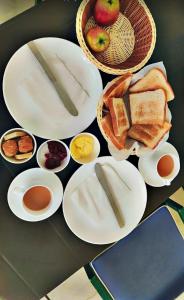 a table with plates of bread and bowls of food at Arti's Homestay in Agra