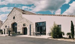 a white building with a table outside of it at "La Petite Félixière" à 25 min du Puy du Foù, 10 min de Cholet, et 35 min de Nantes in Saint-André-de-la-Marche