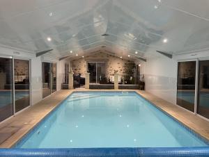 a large swimming pool in a house with a ceiling at "La Petite Félixière" à 25 min du Puy du Foù, 10 min de Cholet, et 35 min de Nantes in Saint-André-de-la-Marche