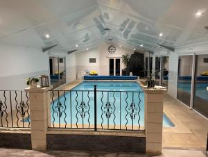 a swimming pool in a house with a fence at "La Petite Félixière" à 25 min du Puy du Foù, 10 min de Cholet, et 35 min de Nantes in Saint-André-de-la-Marche