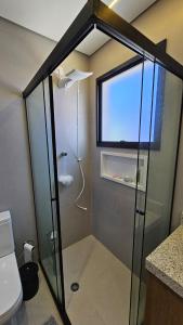 a shower with a glass door in a bathroom at Apartamento com 1 suíte, 1 lavabo, 1 vaga a 70m da Praia in Praia Grande