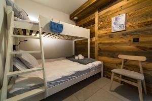 Appartement Haut de Gamme au cœur du village avec terrasse de 34m2 - 6 personnes في سانت سورلين دوارفيز: غرفة نوم مع سرير بطابقين وكرسي ومكتب