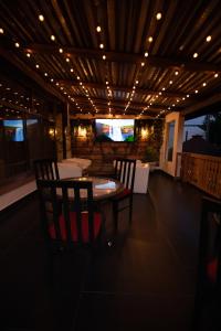 a dining room with a table and chairs and lights at Pensiunea Carol Oglinzi in Oglinzi