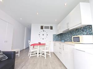 eine Küche mit einem Tisch und einer Uhr an der Wand in der Unterkunft Los Molinos 503 in San Bartolomé de Tirajana