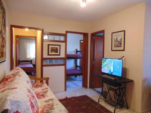 a bedroom with a bed and a television on a desk at Vila Secreta in Campos do Jordão