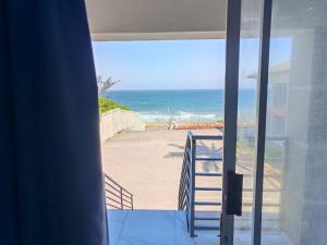 a view of the ocean from a house balcony at Modern Beachfront Escape in La Mercy in La Mercy