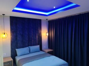 a bedroom with a bed and a blue ceiling at Modern Beachfront Escape in La Mercy in La Mercy