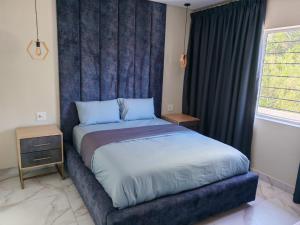 a bed with a blue headboard in a bedroom at Modern Beachfront Escape in La Mercy in La Mercy