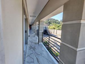 a building with a balcony with a view of a train track at Modern Beachfront Escape in La Mercy in La Mercy