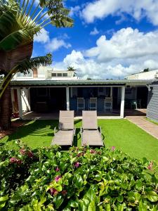 two chairs sitting on the lawn of a house at Maison bord de mer in Le Gosier