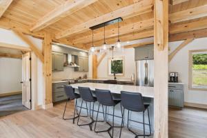 eine Küche mit einer großen Insel mit Barhockern in der Unterkunft Black Rock Lodge in Stowe
