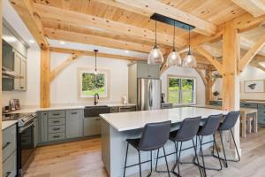 eine Küche mit einer großen Kücheninsel mit Barhockern in der Unterkunft Black Rock Lodge in Stowe